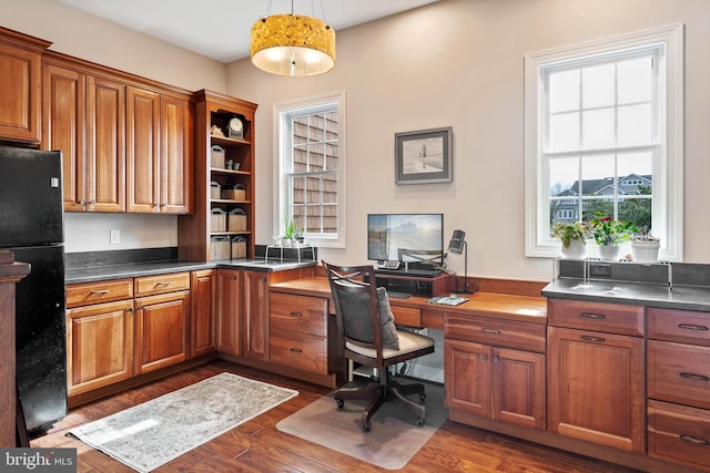 office featuring plenty of natural light, dark hardwood / wood-style floors, and built in desk