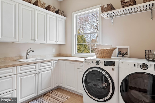 clothes washing area featuring washer hookup, independent washer and dryer, sink, light tile floors, and cabinets