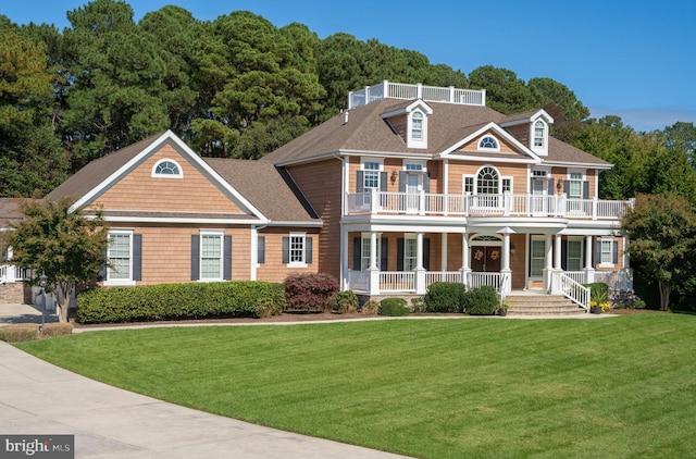 colonial-style house with a front lawn, a balcony, and covered porch