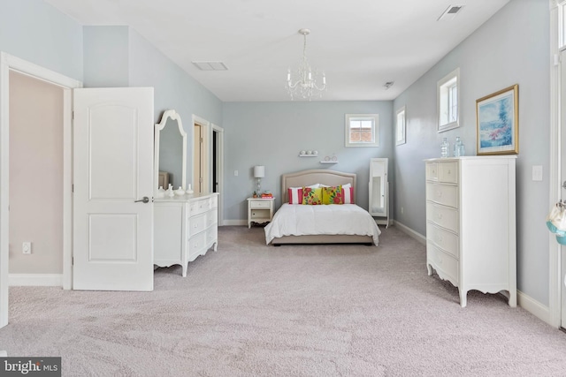 bedroom featuring an inviting chandelier and light colored carpet