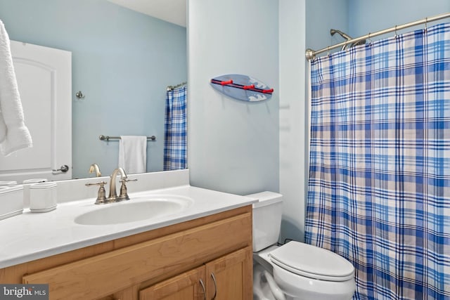 bathroom featuring toilet and vanity with extensive cabinet space