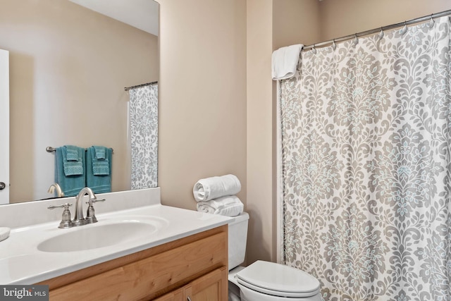 bathroom with toilet and large vanity