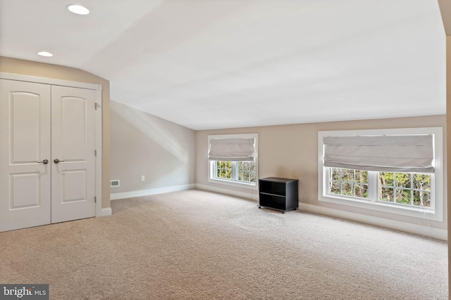 unfurnished living room featuring light carpet and lofted ceiling