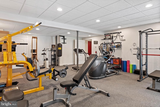 workout area with a paneled ceiling and carpet