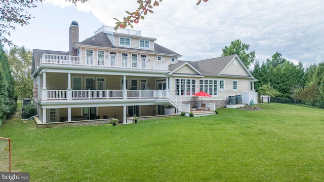 back of house with a balcony and a yard