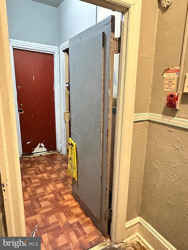 hallway featuring dark parquet flooring