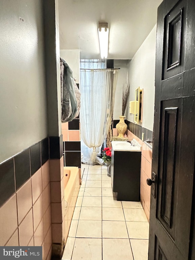 bathroom with tile walls, toilet, tile floors, and vanity with extensive cabinet space