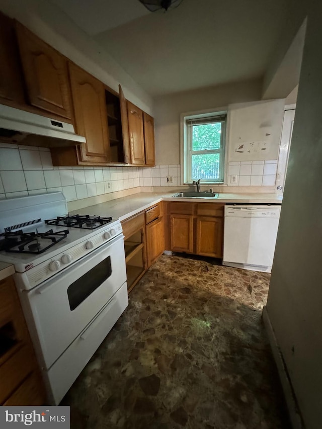 kitchen featuring white appliances, tasteful backsplash, and sink