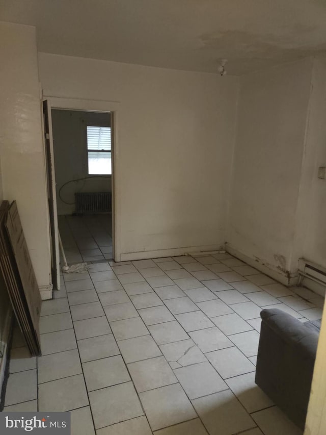 unfurnished room with light tile floors and radiator