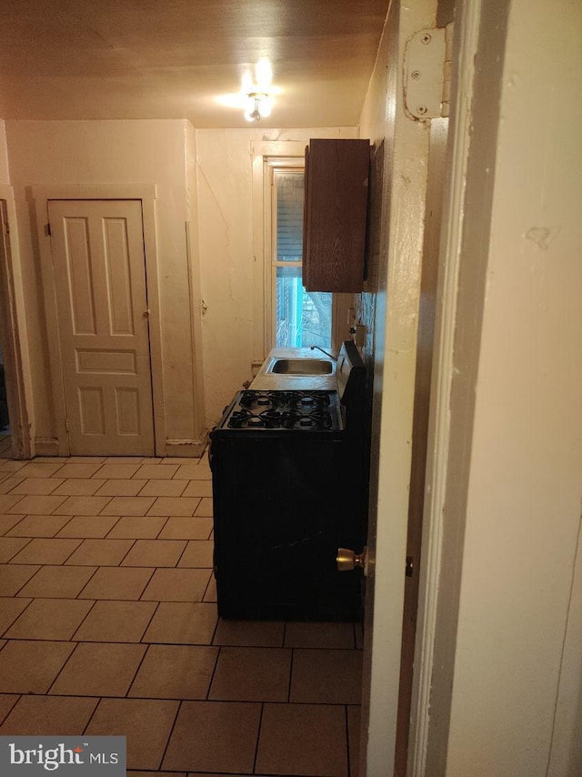 interior space featuring dark tile flooring, range, and sink