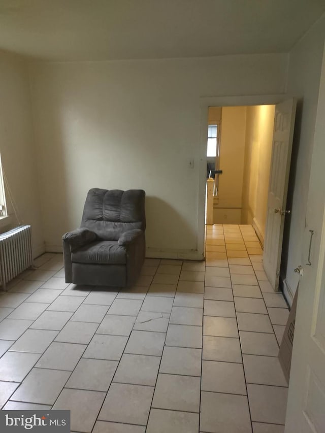 unfurnished room featuring radiator and light tile flooring