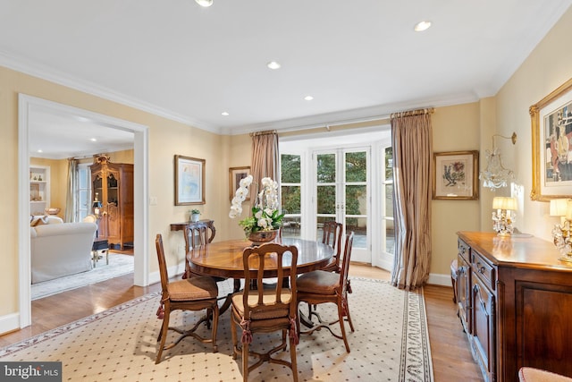 dining room with ornamental molding and light wood-type flooring