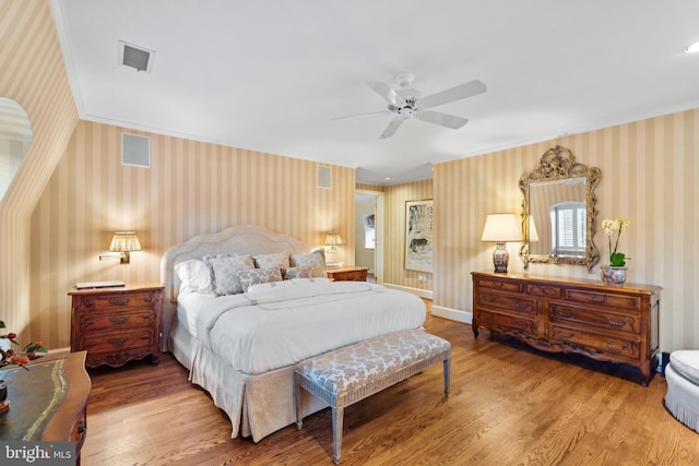 bedroom with crown molding, ceiling fan, and light wood-type flooring