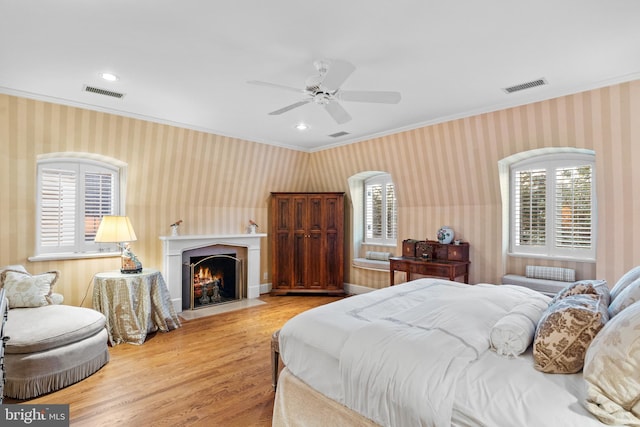 bedroom with ceiling fan, crown molding, and light wood-type flooring