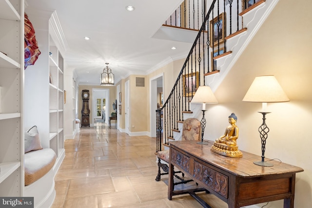 entrance foyer with crown molding, light tile flooring, and a chandelier