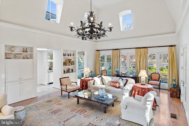 living room with crown molding, a notable chandelier, plenty of natural light, and light hardwood / wood-style floors