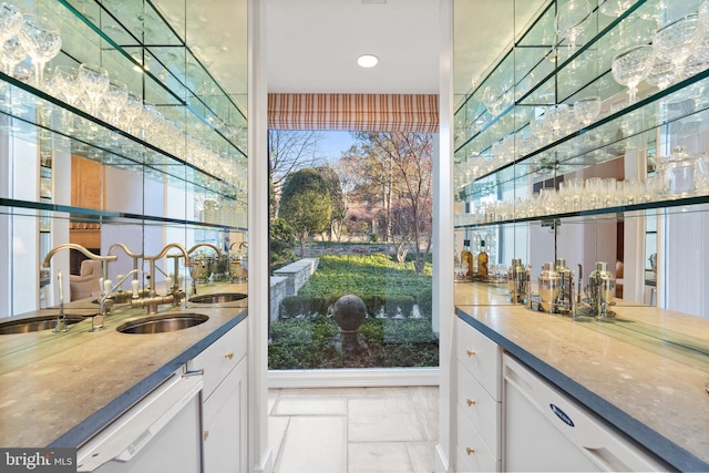 bar featuring light tile flooring, sink, white cabinets, and dishwasher