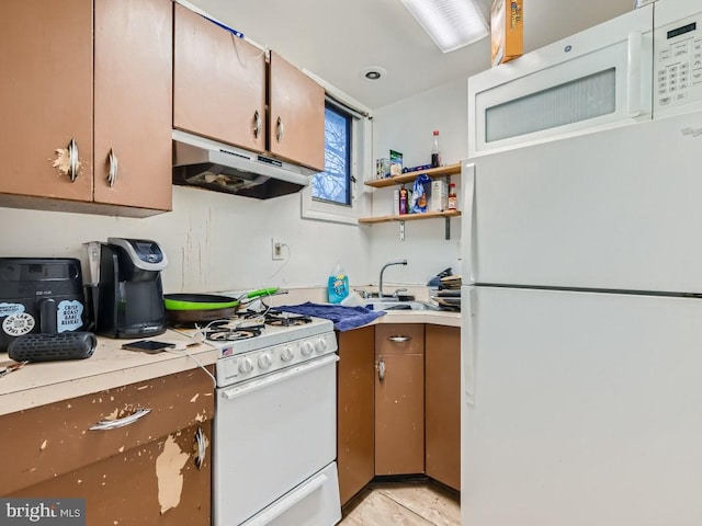 kitchen featuring sink, light tile patterned flooring, and white appliances