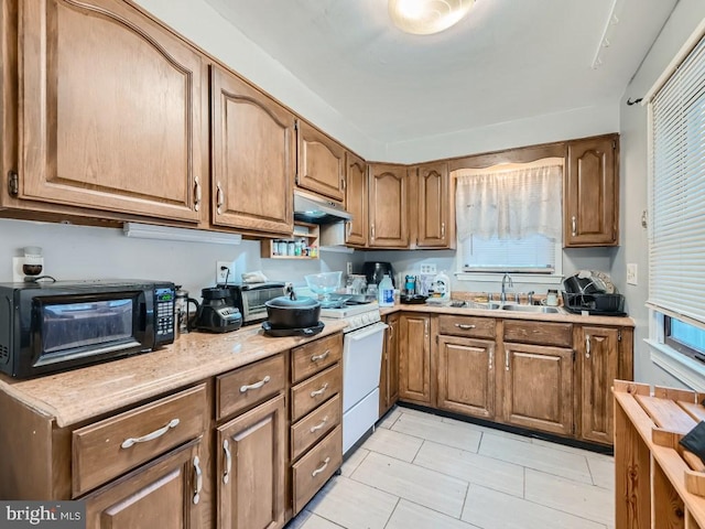 kitchen with light tile patterned floors, white range oven, and sink