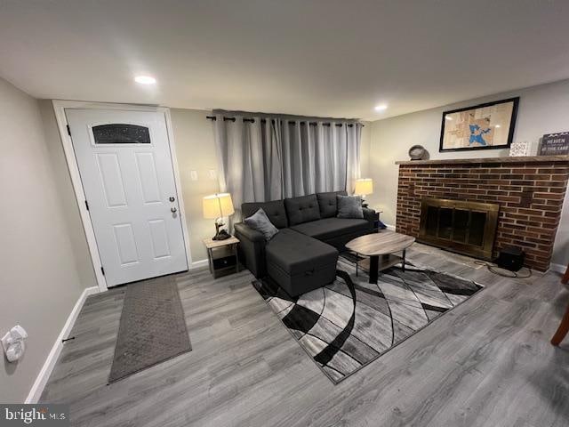 living room featuring light hardwood / wood-style floors and a brick fireplace