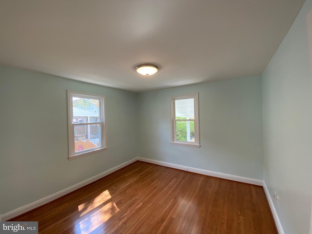 empty room with wood-type flooring and a wealth of natural light