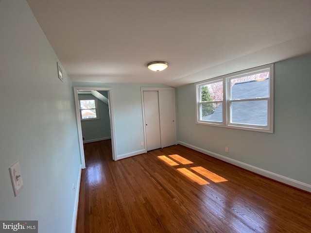 unfurnished bedroom featuring dark hardwood / wood-style floors and multiple windows