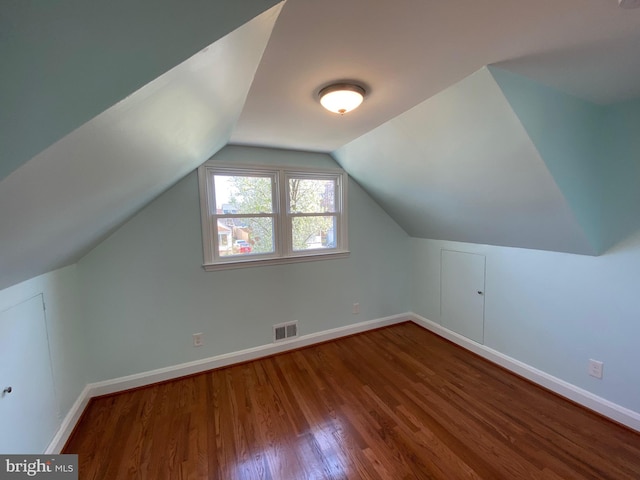 additional living space with lofted ceiling and dark wood-type flooring