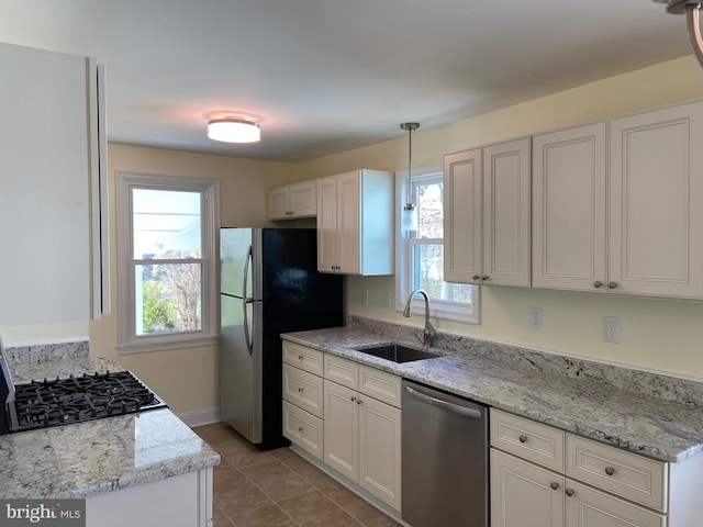 kitchen featuring light tile flooring, sink, stainless steel appliances, and a healthy amount of sunlight