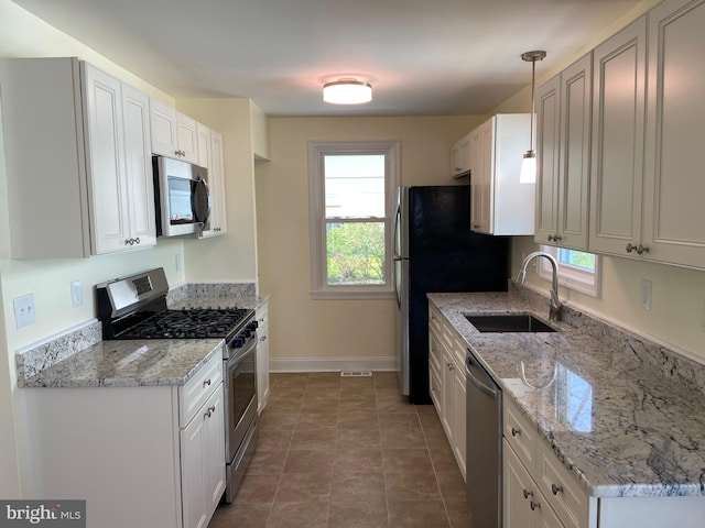 kitchen featuring stainless steel appliances, white cabinetry, and dark tile flooring