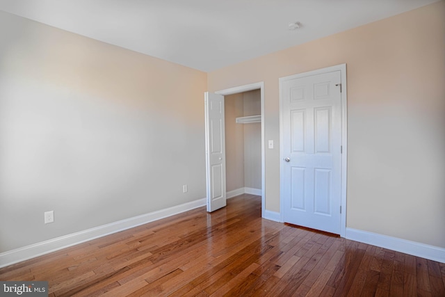 unfurnished bedroom featuring a closet and dark wood-type flooring