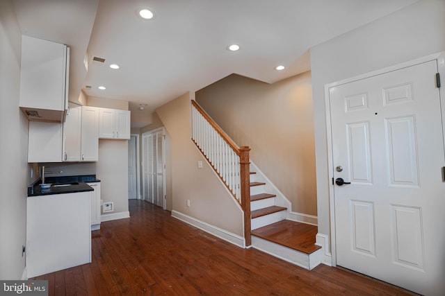 stairs with sink and dark hardwood / wood-style floors