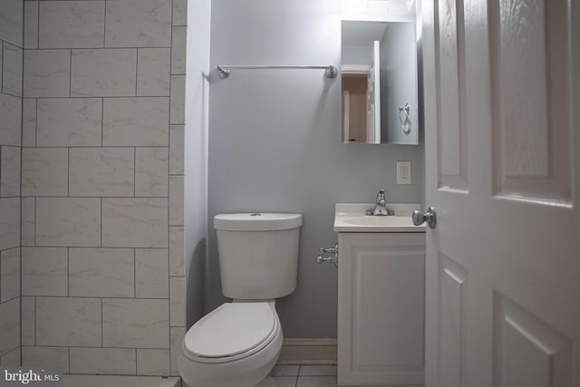 bathroom with toilet, tile floors, and vanity