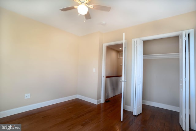 unfurnished bedroom featuring ceiling fan, a closet, and dark wood-type flooring