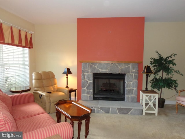 carpeted living room featuring a stone fireplace