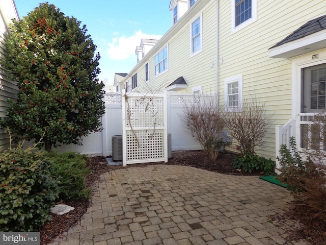 view of gate featuring central AC unit and a patio area