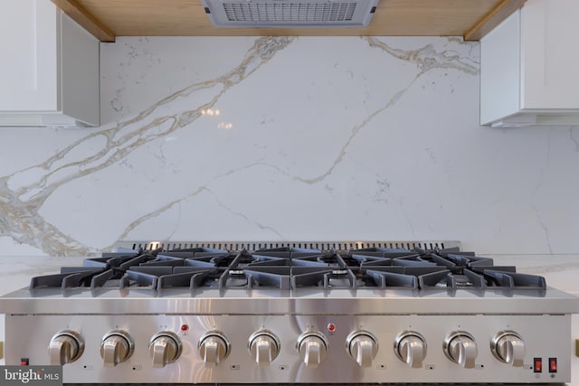 5824 Wild Lilac Dr, Lot East Petersburg, PA 17520 - details featuring light stone counters, stove, visible vents, white cabinets, and decorative backsplash