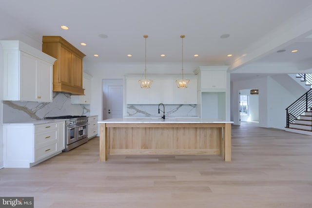 5824 Wild Lilac Dr, Lot East Petersburg, PA 17520 - kitchen with double oven range, a center island with sink, white cabinets, and light wood-style flooring