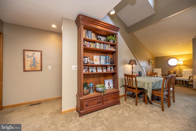 carpeted dining room featuring lofted ceiling