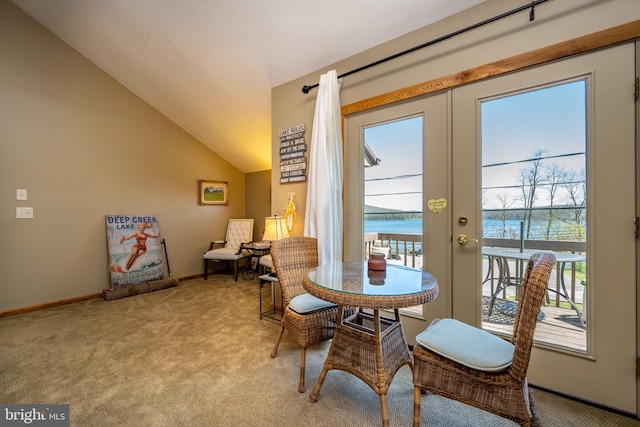 living area featuring light carpet, french doors, a water view, and vaulted ceiling