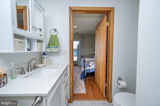 bathroom featuring toilet, hardwood / wood-style floors, and vanity