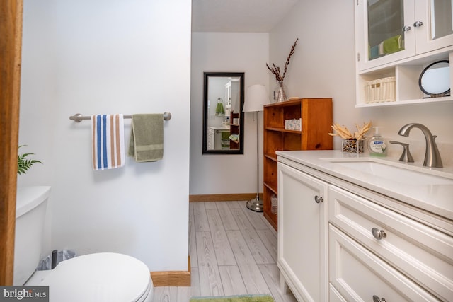 bathroom with vanity, hardwood / wood-style floors, and toilet