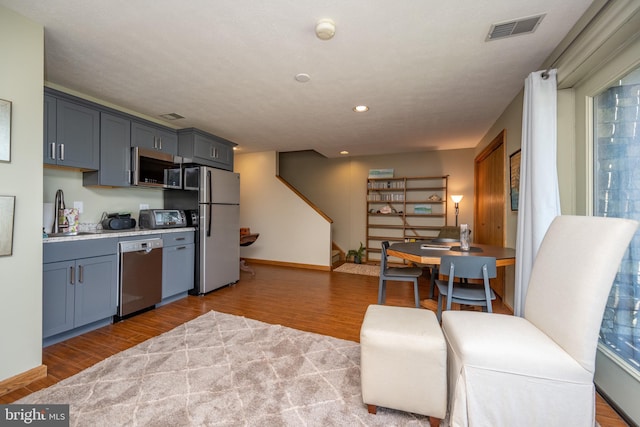 kitchen with a healthy amount of sunlight, appliances with stainless steel finishes, and wood-type flooring