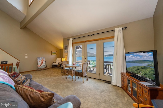 carpeted living room with lofted ceiling with beams, french doors, and a water view