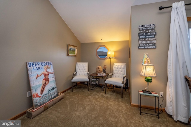 sitting room featuring dark colored carpet and lofted ceiling