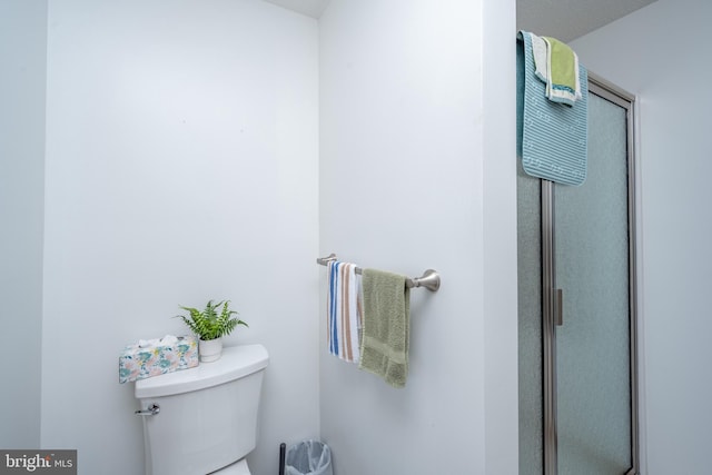 bathroom featuring walk in shower and toilet