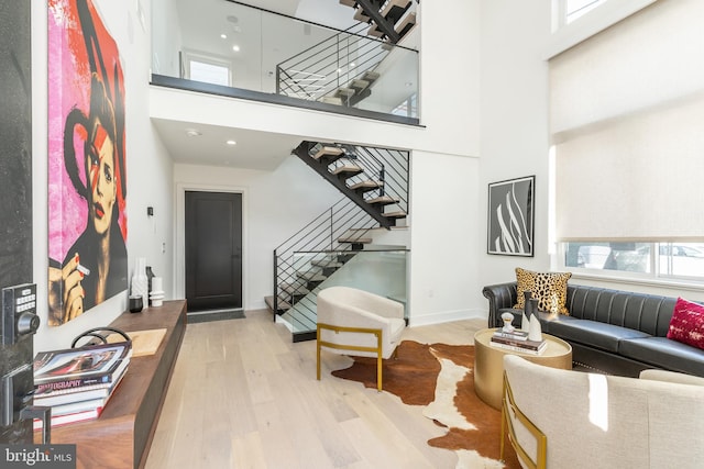 interior space featuring a towering ceiling and light hardwood / wood-style floors