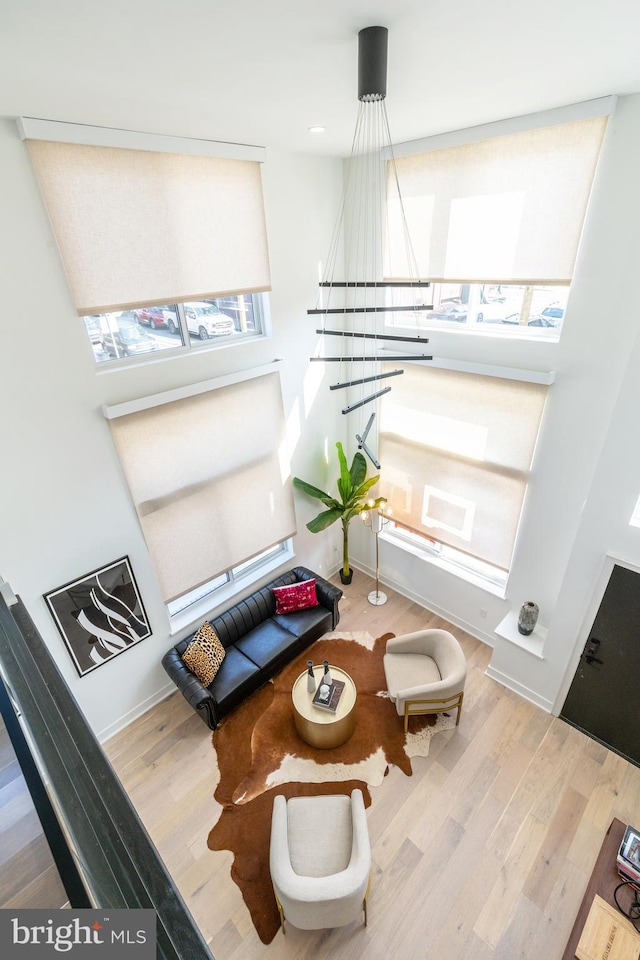 living area featuring a notable chandelier and light hardwood / wood-style floors