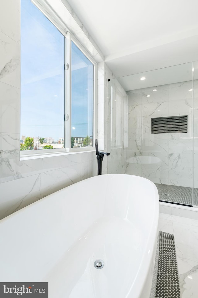 bathroom with tile walls, tile flooring, and a tile shower