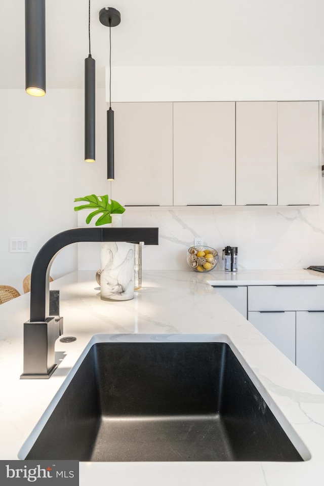 interior details featuring sink and tasteful backsplash