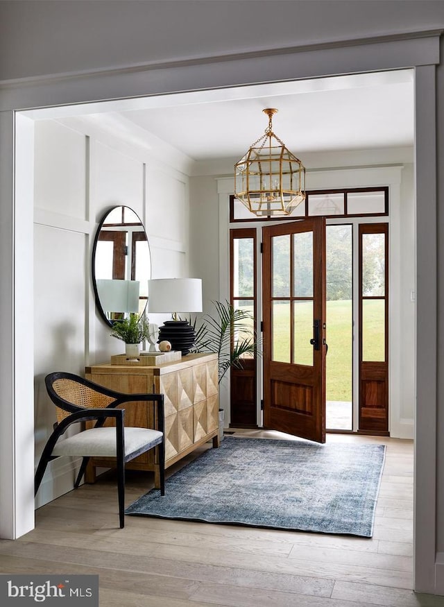 doorway with a notable chandelier and light hardwood / wood-style flooring